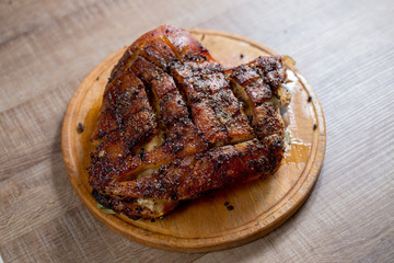 roast pork meat but with a bone on a wooden board