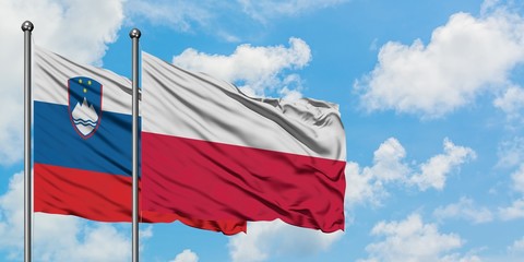 Slovenia and Poland flag waving in the wind against white cloudy blue sky together. Diplomacy concept, international relations.