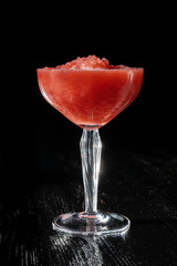 Strawberry daiquiri cocktail with strawberry syrop, on black background.