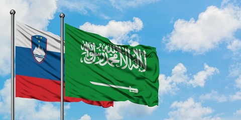 Slovenia and Saudi Arabia flag waving in the wind against white cloudy blue sky together. Diplomacy concept, international relations.