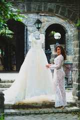 Young beautiful bride preparing to try on her luxury bridal dress