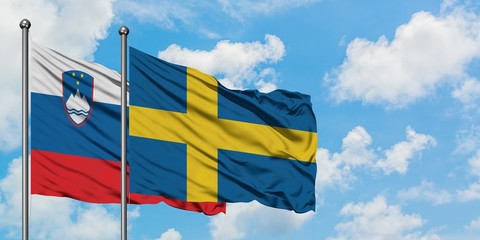 Slovenia and Sweden flag waving in the wind against white cloudy blue sky together. Diplomacy concept, international relations.