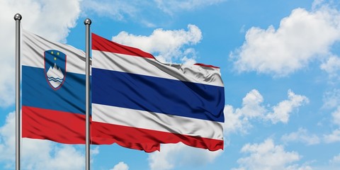 Slovenia and Thailand flag waving in the wind against white cloudy blue sky together. Diplomacy concept, international relations.