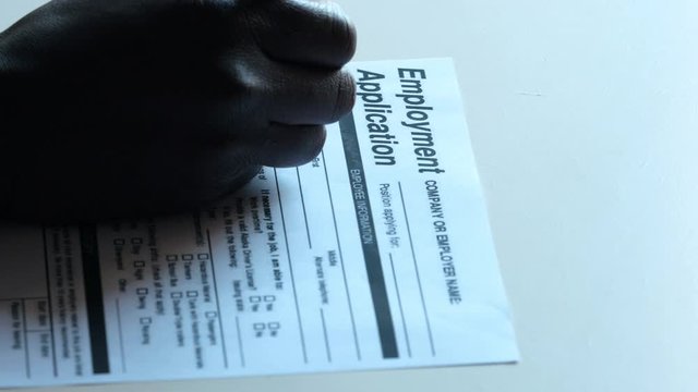 Search,job,inoccupation. Black man's hand filling job application