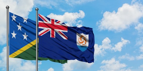 Solomon Islands and Anguilla flag waving in the wind against white cloudy blue sky together....