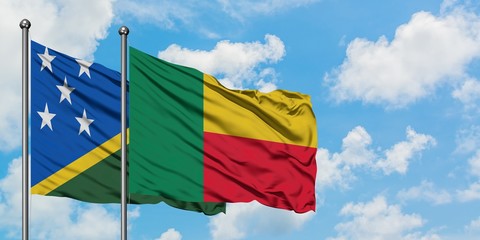 Solomon Islands and Benin flag waving in the wind against white cloudy blue sky together. Diplomacy concept, international relations.
