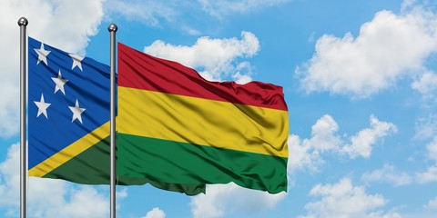 Solomon Islands and Bolivia flag waving in the wind against white cloudy blue sky together. Diplomacy concept, international relations.