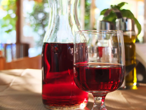 Jug and a glass of red wine in a sunny afternoon