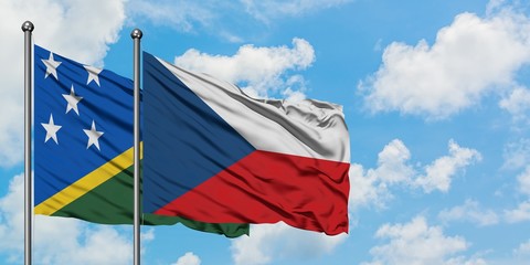 Solomon Islands and Czech Republic flag waving in the wind against white cloudy blue sky together....