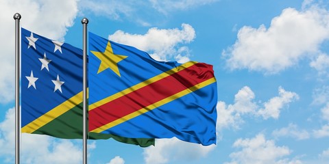 Solomon Islands and Congo flag waving in the wind against white cloudy blue sky together. Diplomacy concept, international relations.