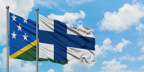 Solomon Islands and Finland flag waving in the wind against white cloudy blue sky together. Diplomacy concept, international relations.