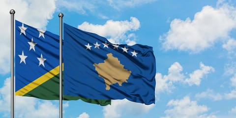 Solomon Islands and Kosovo flag waving in the wind against white cloudy blue sky together. Diplomacy concept, international relations.