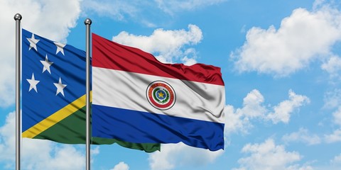 Solomon Islands and Paraguay flag waving in the wind against white cloudy blue sky together. Diplomacy concept, international relations.