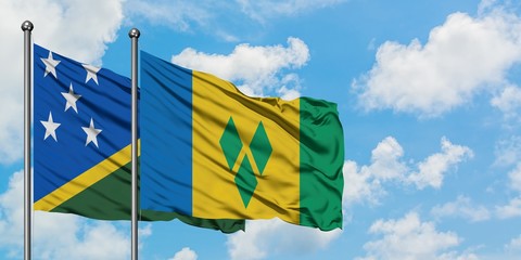 Solomon Islands and Saint Vincent And The Grenadines flag waving in the wind against white cloudy...