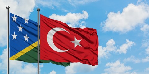 Solomon Islands and Turkey flag waving in the wind against white cloudy blue sky together. Diplomacy concept, international relations.