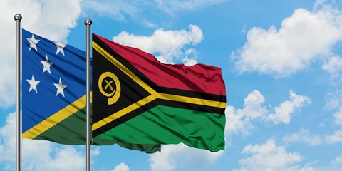 Solomon Islands and Vanuatu flag waving in the wind against white cloudy blue sky together. Diplomacy concept, international relations.