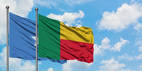 Somalia and Benin flag waving in the wind against white cloudy blue sky together. Diplomacy...