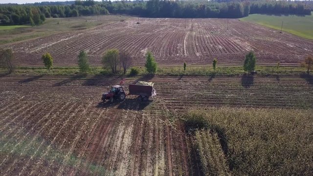 Aerial shot of a tractor making a U turn to start harvesting corn from a new row.
