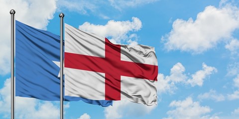 Somalia and England flag waving in the wind against white cloudy blue sky together. Diplomacy concept, international relations.