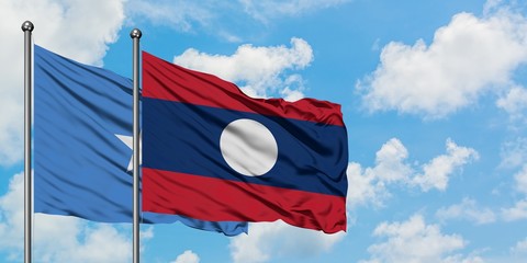 Somalia and Laos flag waving in the wind against white cloudy blue sky together. Diplomacy concept, international relations.