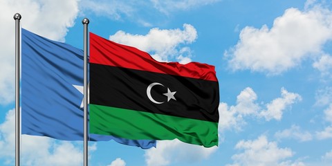 Somalia and Libya flag waving in the wind against white cloudy blue sky together. Diplomacy concept, international relations.