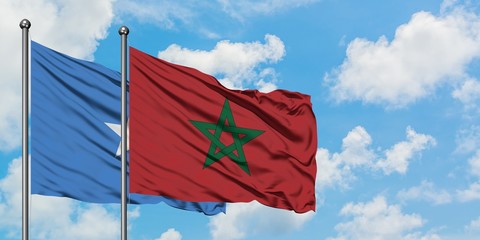 Somalia and Morocco flag waving in the wind against white cloudy blue sky together. Diplomacy concept, international relations.