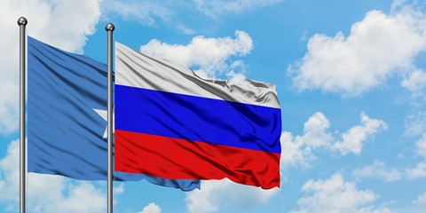 Somalia and Russia flag waving in the wind against white cloudy blue sky together. Diplomacy concept, international relations.