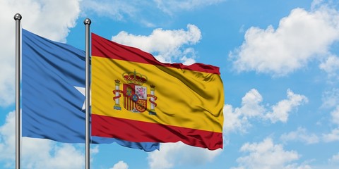 Somalia and Spain flag waving in the wind against white cloudy blue sky together. Diplomacy concept, international relations.