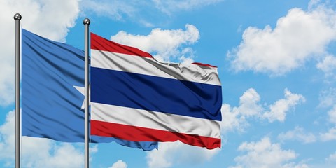Somalia and Thailand flag waving in the wind against white cloudy blue sky together. Diplomacy concept, international relations.