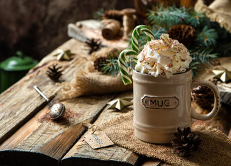 ceramic mug with hot cocoa, chocolate or coffee with whipped cream and christmas candy canes