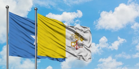 Somalia and Vatican City flag waving in the wind against white cloudy blue sky together. Diplomacy concept, international relations.