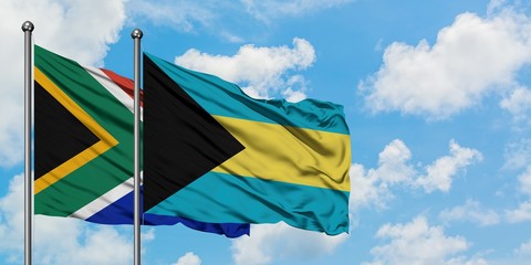 South Africa and Bahamas flag waving in the wind against white cloudy blue sky together. Diplomacy concept, international relations.
