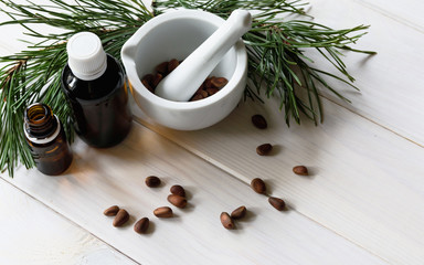 Top view, natural eco product, composition glass bottles with cedar oil, pine nuts, mortar, cedar...