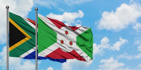 South Africa and Burundi flag waving in the wind against white cloudy blue sky together. Diplomacy concept, international relations.