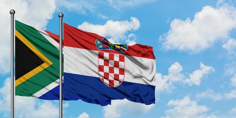 South Africa and Croatia flag waving in the wind against white cloudy blue sky together. Diplomacy concept, international relations.
