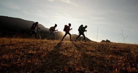 Four young people on hike adventure - Group of students trekking in mountains together, having a vacation - friendship, travel destination concept 4k footage - Powered by Adobe