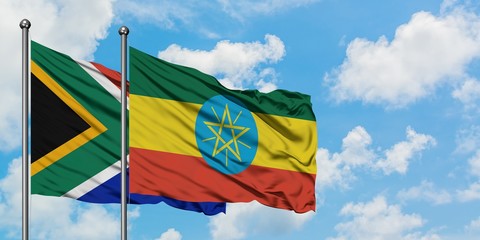 South Africa and Ethiopia flag waving in the wind against white cloudy blue sky together. Diplomacy concept, international relations.