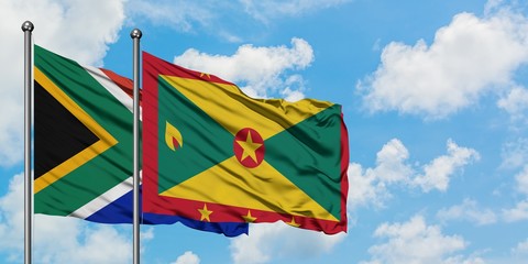 South Africa and Grenada flag waving in the wind against white cloudy blue sky together. Diplomacy concept, international relations.