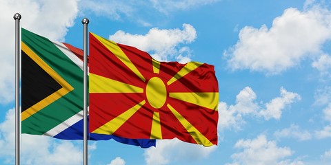 South Africa and Macedonia flag waving in the wind against white cloudy blue sky together. Diplomacy concept, international relations.