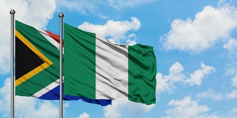 South Africa and Nigeria flag waving in the wind against white cloudy blue sky together. Diplomacy concept, international relations.