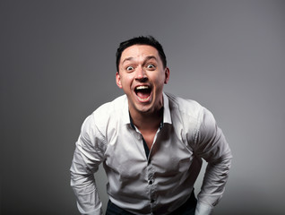 Obraz premium Excited crazy man shouting loud with wide opened mouth and mad eyes. Closeup