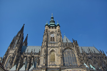 Fototapeta premium A large Gothic church with a clock against a cloudless sky in Prague, Czech Republic.