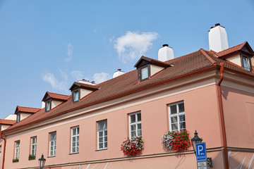 A building of pastel pink color with a roof of red tiles in Prague, Czech Republic.
