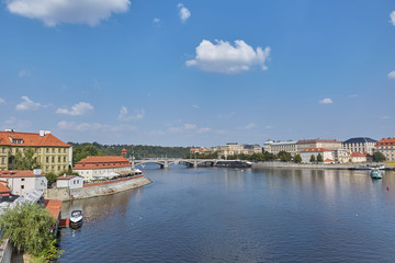 Fototapeta na wymiar A wide river with a bridge in Prague, the Czech Republic.