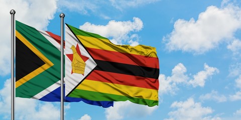 South Africa and Zimbabwe flag waving in the wind against white cloudy blue sky together. Diplomacy concept, international relations.