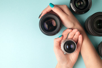 set of photo lenses on a colored background, the selection and comparison of photographic equipment, hands are holding photo equipment