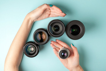 set of photo lenses on a colored background, the selection and comparison of photographic equipment, hands are holding photo equipment