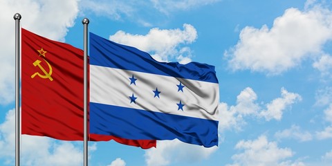 Soviet Union and Honduras flag waving in the wind against white cloudy blue sky together. Diplomacy...