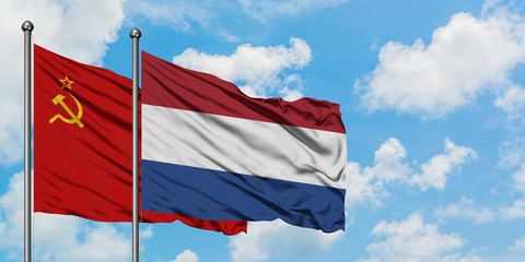 Soviet Union and Netherlands flag waving in the wind against white cloudy blue sky together. Diplomacy concept, international relations.