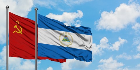 Soviet Union and Nicaragua flag waving in the wind against white cloudy blue sky together....